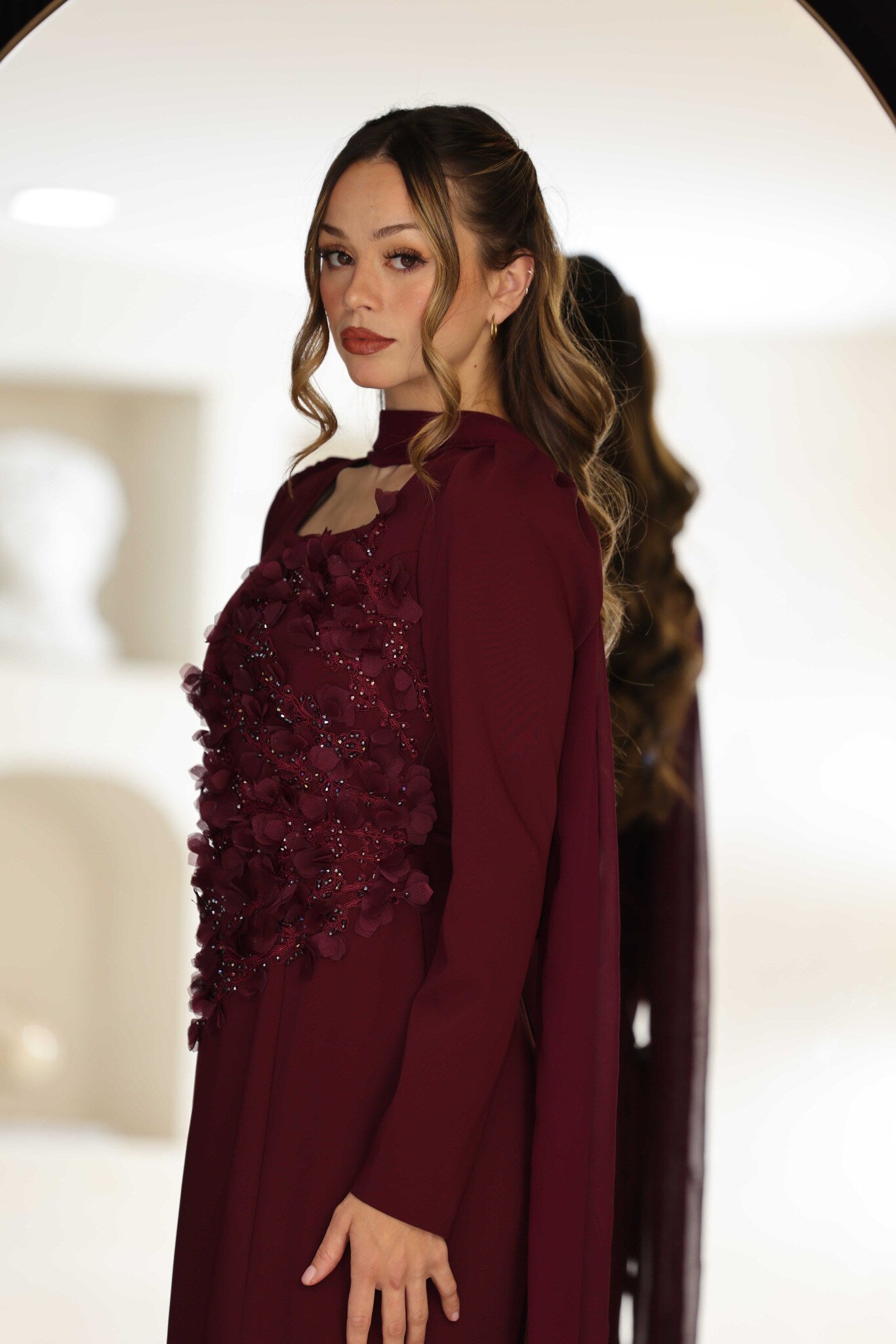 Burgundy dress with floral hand-beaded appliqué detailing.