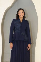 Navy blue pleated midi dress with floral appliqué and beaded detailing on the bodice.