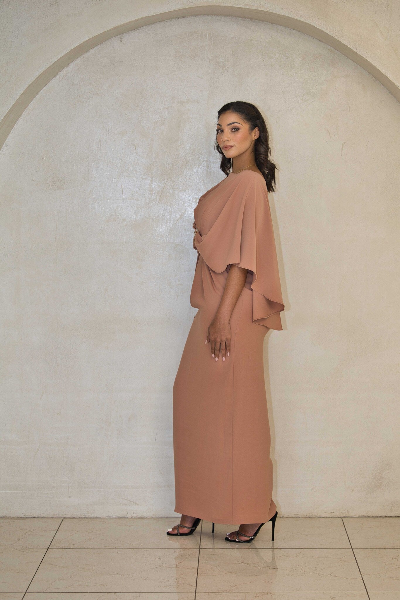 Full-length cinnamon satin dress with beaded detailing and flowy sleeves.