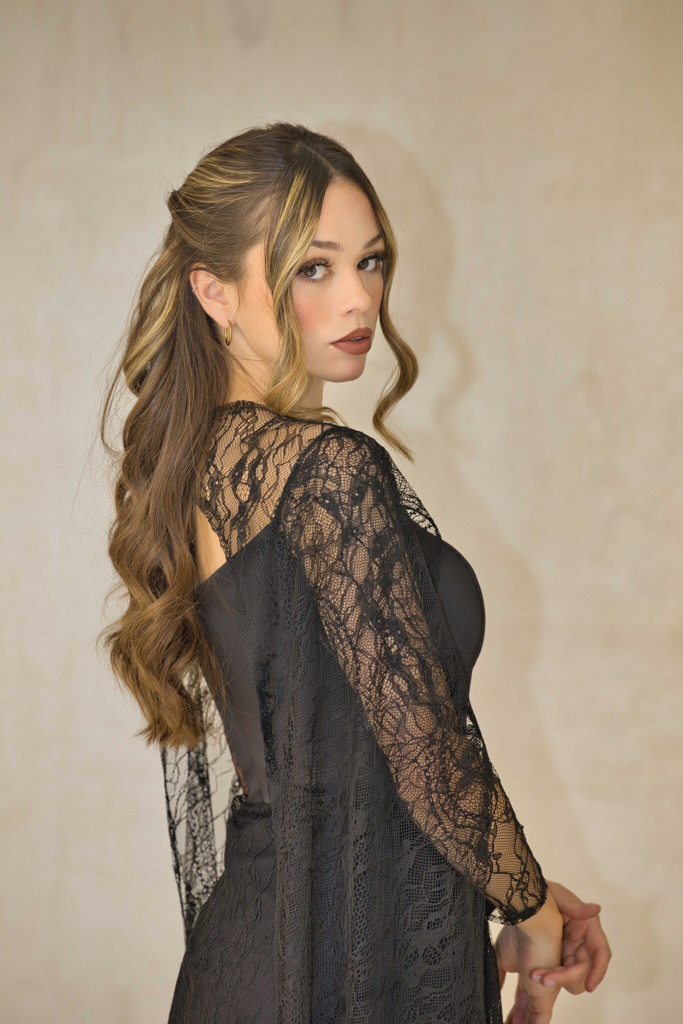 Lace evening dress with fitted corset bodice and cape sleeves.