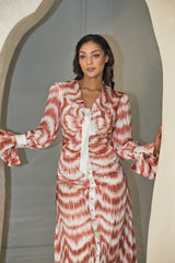 Cinnamon and white printed satin dress with a fluid silhouette.