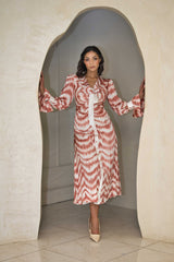 Cinnamon and white printed satin dress with a fluid silhouette.