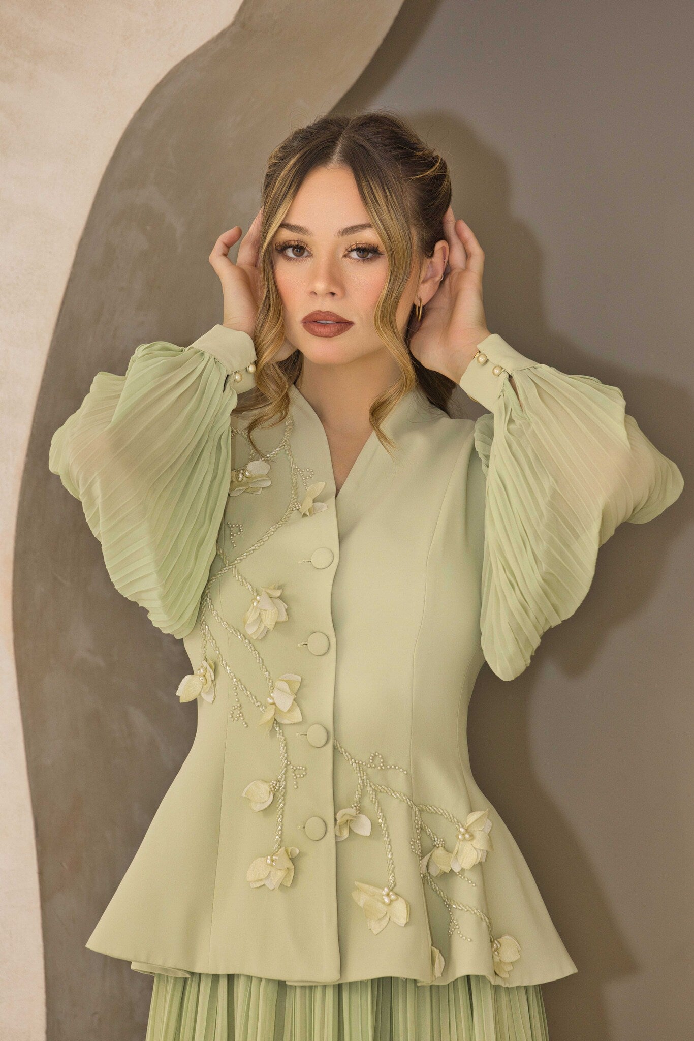 Pistachio green pleated dress with floral appliqué and hand-beaded detailing on the bodice.