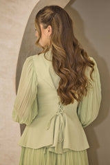 Pistachio green pleated dress with floral appliqué and hand-beaded detailing on the bodice.